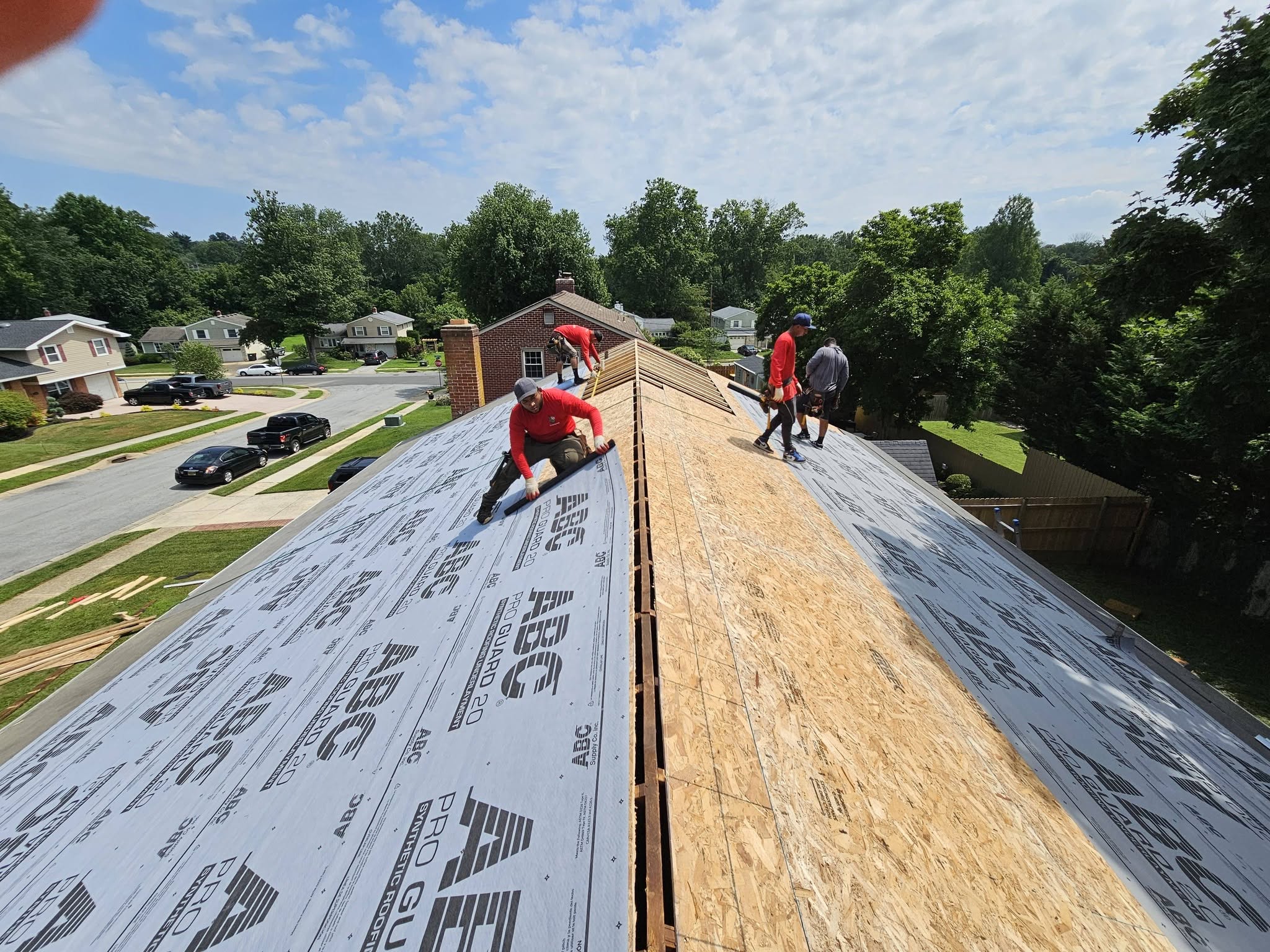 Crew installing new roof decking and underlayment